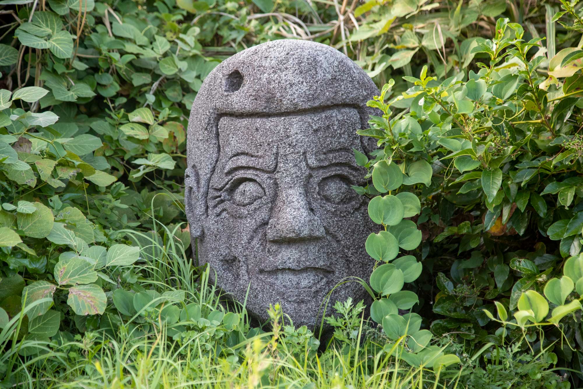 坊主頭の人の顔が彫られた石像（モヤイ像）