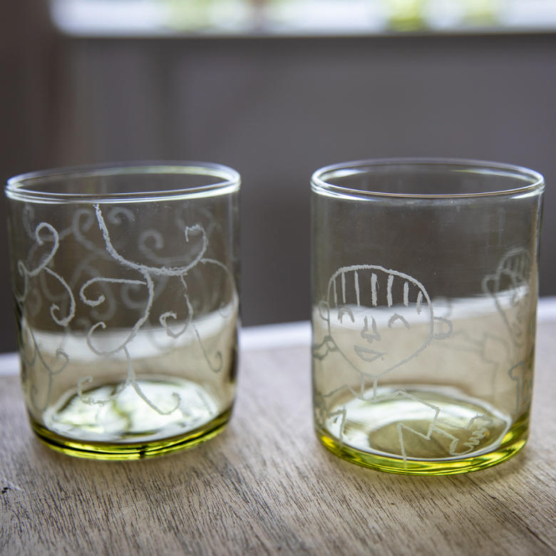 手作り感あふれる模様が入った小さなグラスが2つ、透き通ったオリーブ色