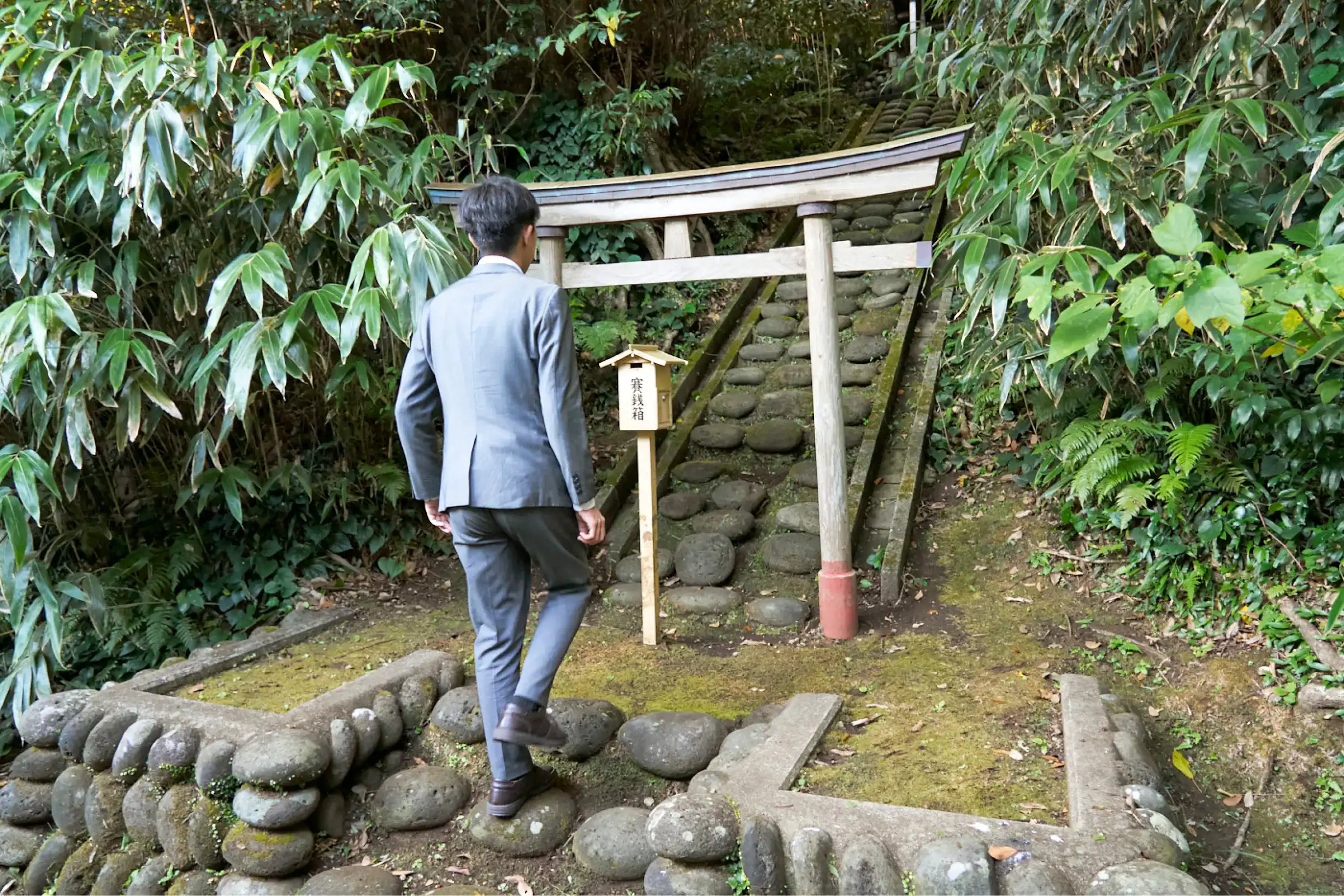 大山小山神社の鳥居に近づくスーツさん