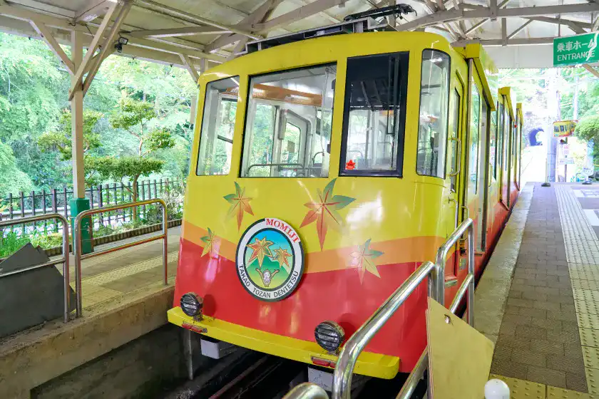 駅に停まっている黄色い車体のケーブルカー