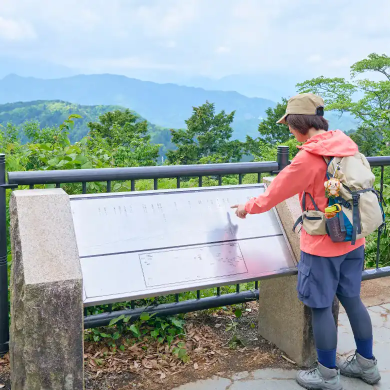 掲示板を見ながら、そこから見える山の位置と名称を照らし合わせるかほさん