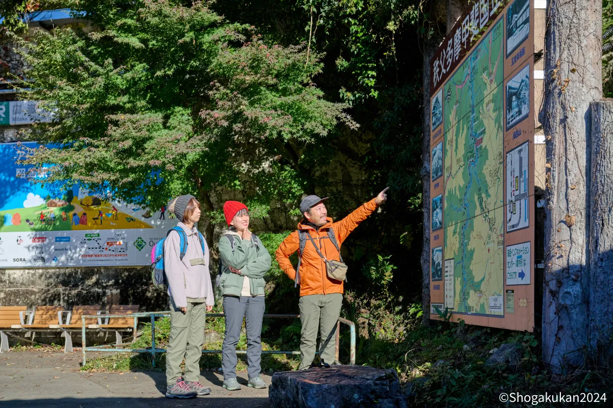 案内板を見て現在地を確認する三人