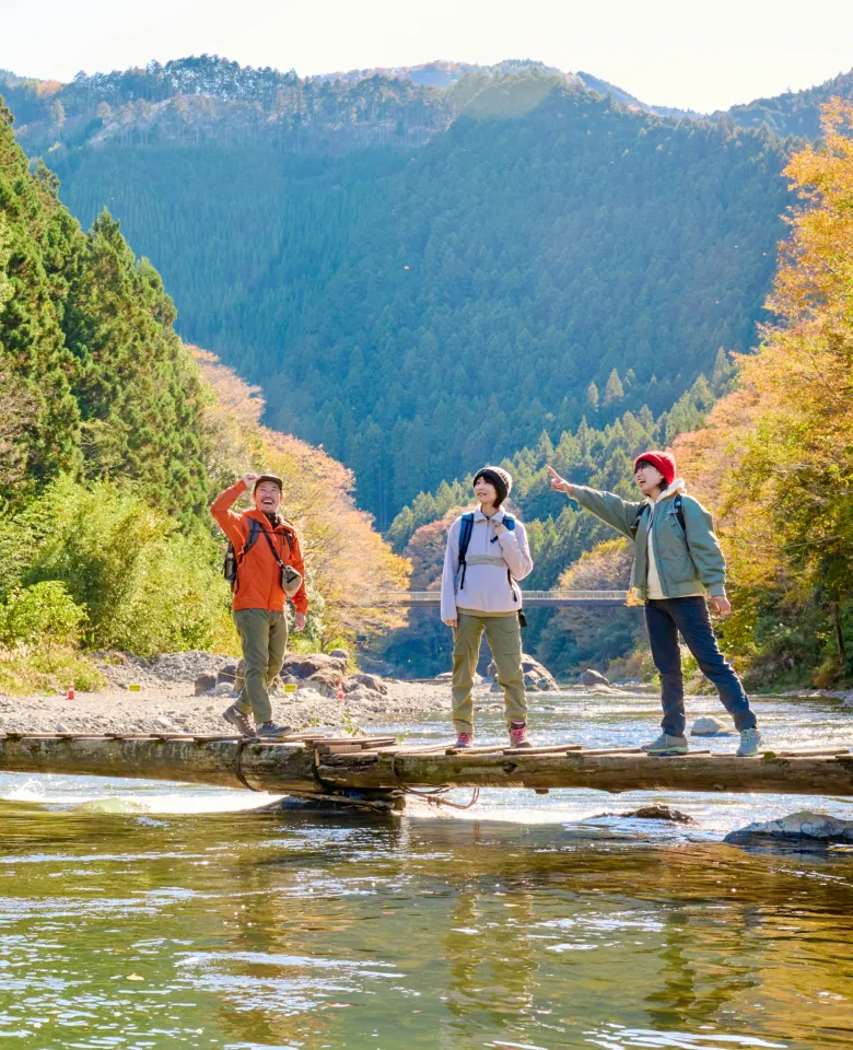 青梅の紅葉と川を楽しむ三人