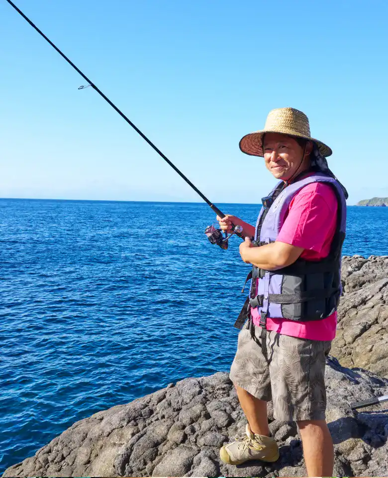 式根島の青い海をバックに、釣りを楽しむとくさん