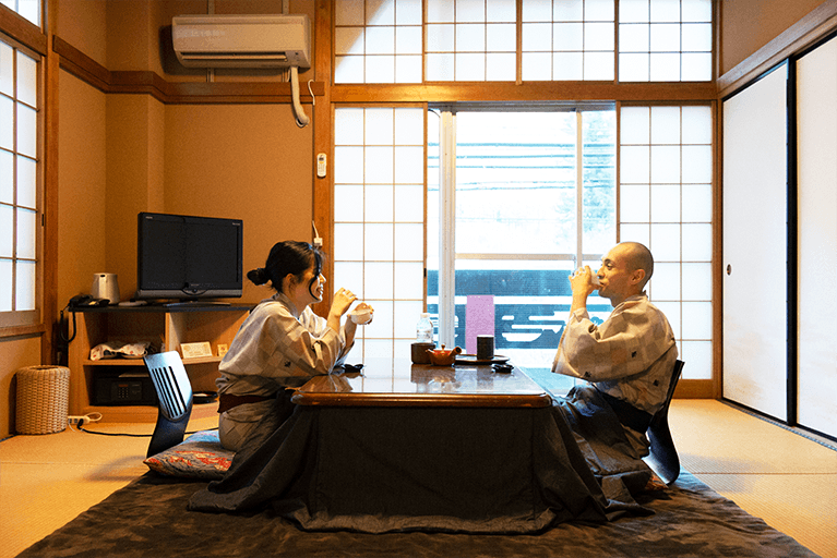 窓から多摩川支流を望める客室。室内や１階の居酒屋では奥多摩の地酒《澤乃井》など、日本酒ソムリエによる利き酒を楽しむことも。